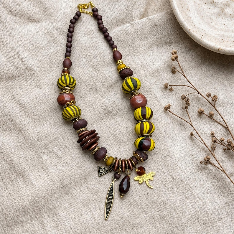 Brown and Yellow Statement Beaded Necklace presented in an open jewelry gift box on natural linen