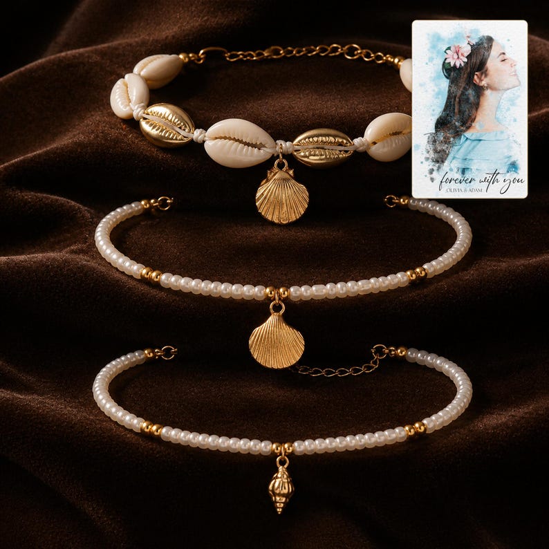 May include: A set of three bracelets featuring a mix of white cowrie shells, gold-toned metallic shells, and small white beads with gold accents. Each bracelet includes a gold-toned shell or spiral charm and a small card with a watercolor illustration.