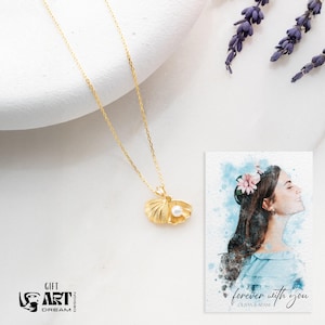 Op de afbeelding: Een goudkleurige ketting met een schelpenhanger en een parel. De ketting wordt getoond met een kaart met de tekst "forever with you" en een aquarelportret van een vrouw. Lavendel takjes zijn ook aanwezig.