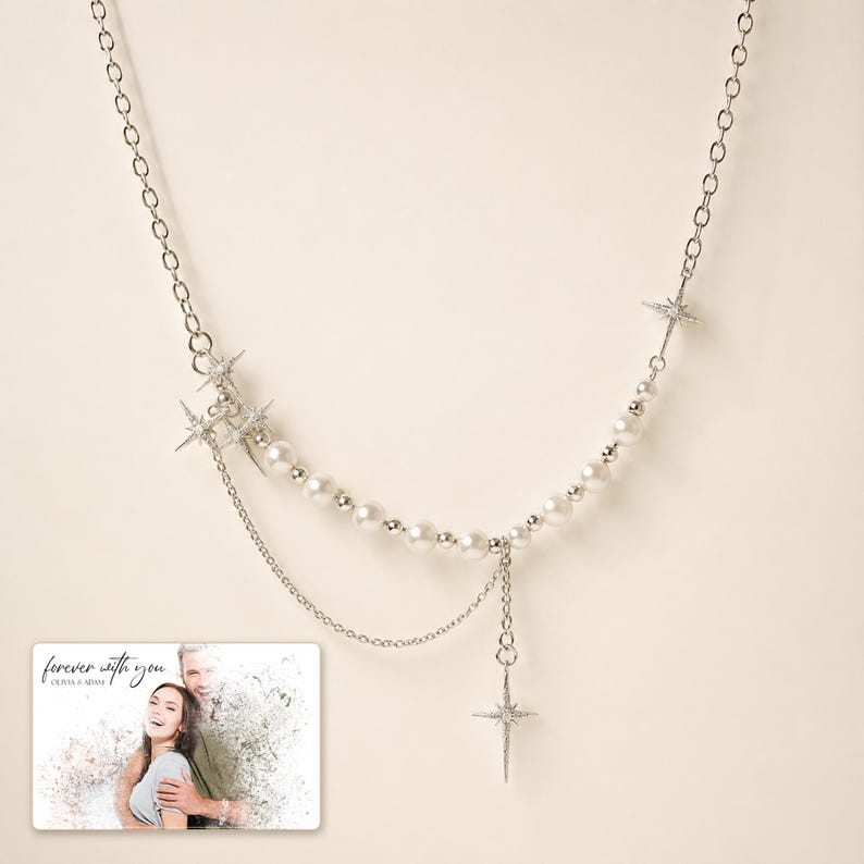 Silver-tone layered necklace with pale beads and pointed star charms, display view. A personalized greeting-card example appears in the corner.
