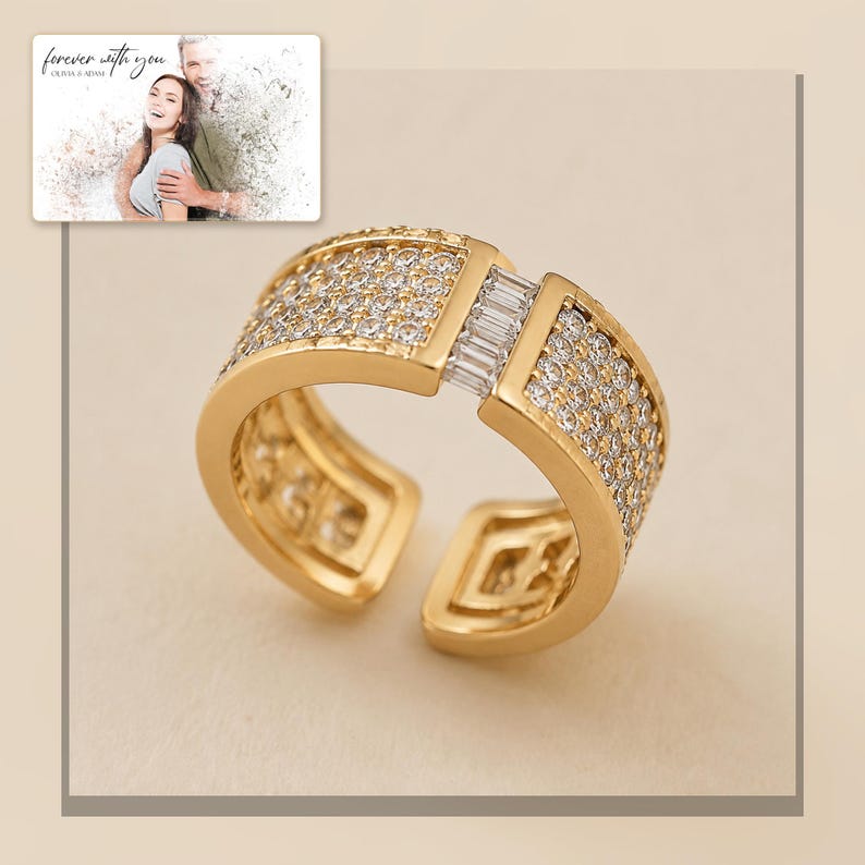 Gold-tone open ring with rows of clear accents, framed product view. A personalized greeting-card example appears in the corner.