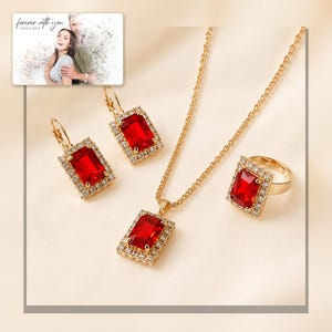 Red rectangular-stone necklace, matching earrings and ring, framed product view. A personalized greeting-card example appears in the corner.