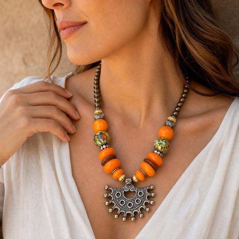 Orange and Brown Statement Beaded Necklace, Boho Handmade Jewelry, Artisan Gift for Her displayed on a jewelry bust with the layered beadwork and pendants visible