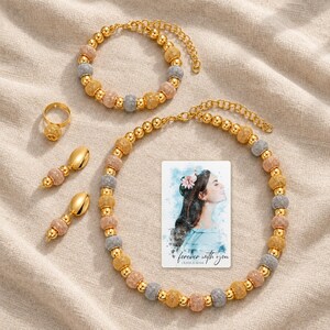 Metallic Bead Jewelry Suite arranged on soft ivory linen in a refined neutral flat lay. A personalized digital greeting card is shown alongside.