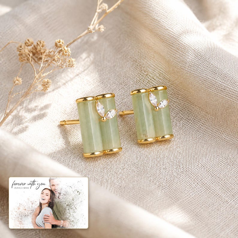 Pale green bamboo-shaped stud earrings with gold-tone edges, framed product view. A personalized greeting-card example appears in the corner.