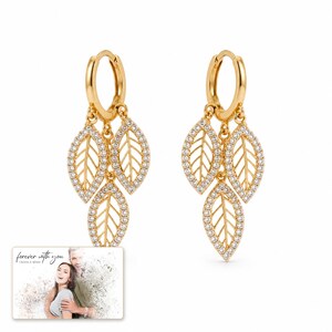 Gilded Leaf Cluster Clips shown during a believable gift-giving moment between adults with the exact jewelry visible.
