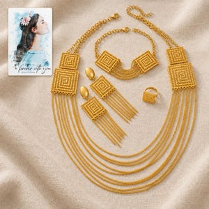 Golden Tassel Jewelry Suite arranged on soft ivory linen in a refined neutral flat lay. A personalized digital greeting card is shown alongside.