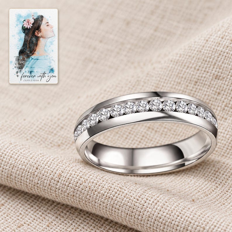 The clear-accent silver-tone band resting on folded oatmeal linen in soft daylight. A personalized digital greeting card is shown alongside.