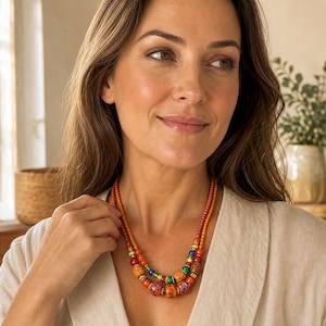 Clear and Orange Statement Beaded Necklace presented in an open jewelry gift box on natural linen