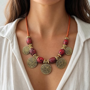 Red Beaded Coin Charm Necklace displayed on a jewelry bust, showing the necklace shape and artisan bead details