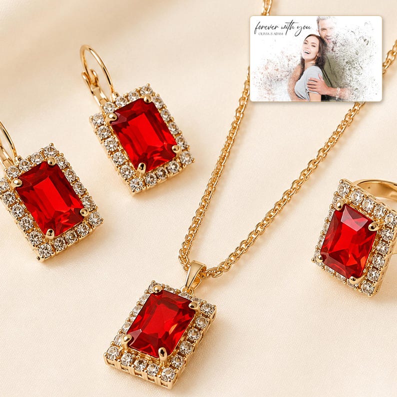 Red rectangular-stone necklace, matching earrings and ring, close detail view. A personalized greeting-card example appears in the corner.