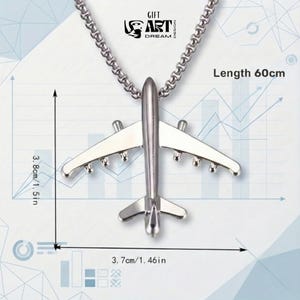 Może przedstawiać: Srebrny naszyjnik z zawieszką w kształcie samolotu. Zawieszka ma 3,7 cm szerokości i 3,8 cm wysokości. Łańcuszek ma 60 cm długości. Naszyjnik ma szczeg&oacute;łowy wz&oacute;r samolotu.