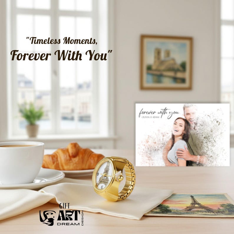 May include: A gold ring watch with a white face showing the Eiffel Tower. The watch sits on a table with a croissant, coffee, and a postcard of the Eiffel Tower. The image includes the text "Timeless Moments, Forever With You."
