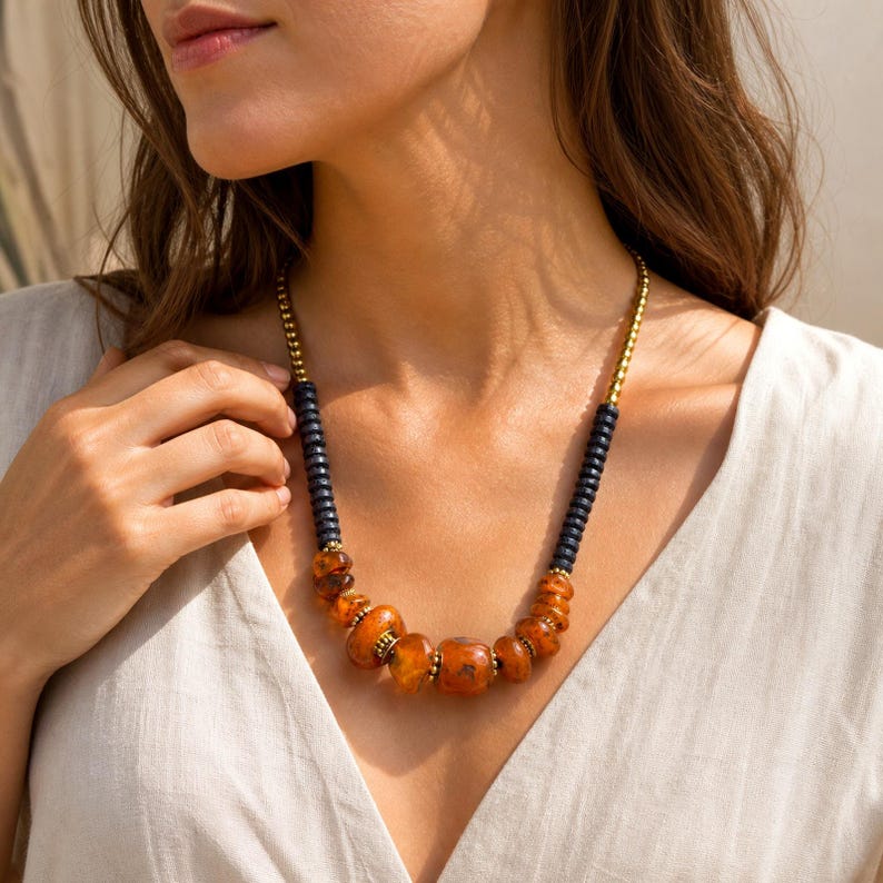 Orange and Brown Statement Beaded Necklace, Boho Handmade Jewelry, Artisan Gift for Her displayed on a jewelry bust with the layered beadwork and pendants visible