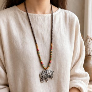 Elephant Pendant Necklace displayed on a jewelry bust, showing the necklace shape and artisan bead details