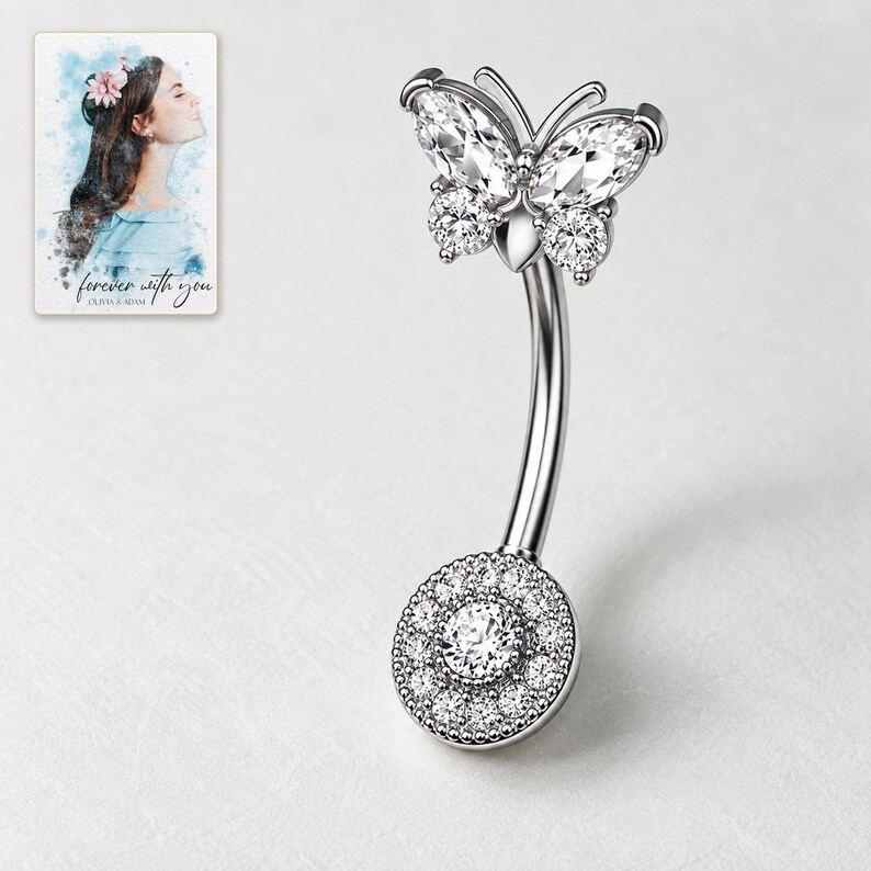 Silver-tone butterfly navel bar with clear marquise upper wings, round lower wings and a pavé disc on pale porcelain. A personalized digital greeting card is shown alongside.