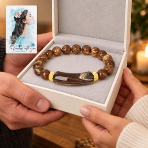 Cocoa Swirl Bar Bracelet shown during a warm gift-receiving moment between adults with the jewelry visible. A personalized digital greeting card is shown alongside.