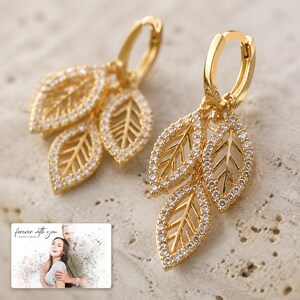 Gilded Leaf Cluster Clips shown during a warm gift-receiving moment between adults with the exact jewelry visible.