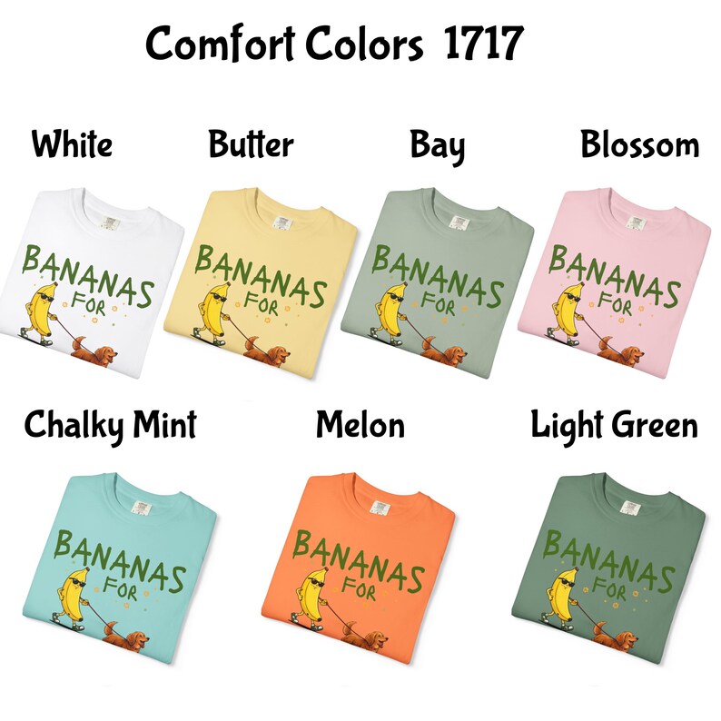 May include: A collection of Comfort Colors 1717 t-shirts in various colors, including white, butter, bay, blossom, chalky mint, melon, and light green. Each shirt features a graphic of a banana with sunglasses walking a dog, with the text "BANANAS FOR".