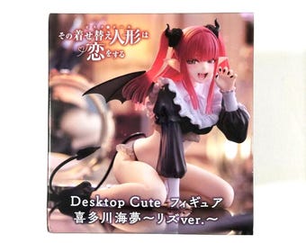 May include: A red-haired anime character with devil horns and wings, wearing a black and white maid outfit, is posed in a sitting position. The figure is part of a Desktop Cute figurine collection. The text on the box reads "その着せ替え人形は恋をする Desktop Cute フィギュア 喜多川海夢〜リズver.~"