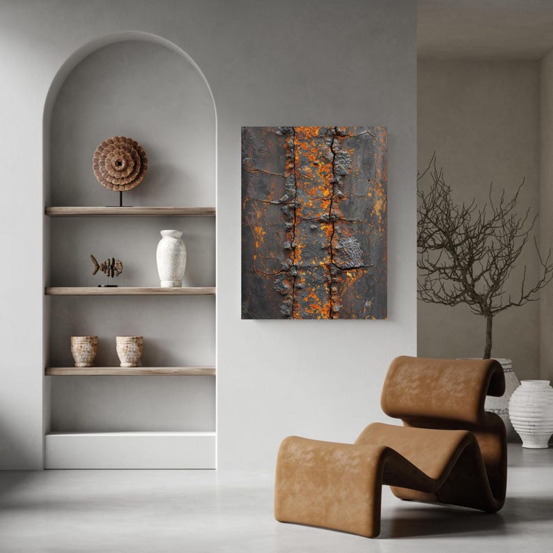 May include: Abstract art piece featuring a close-up of weathered metal with rust-colored accents. The artwork is displayed on a white wall in a modern living space, alongside a brown leather chair and decorative shelving.