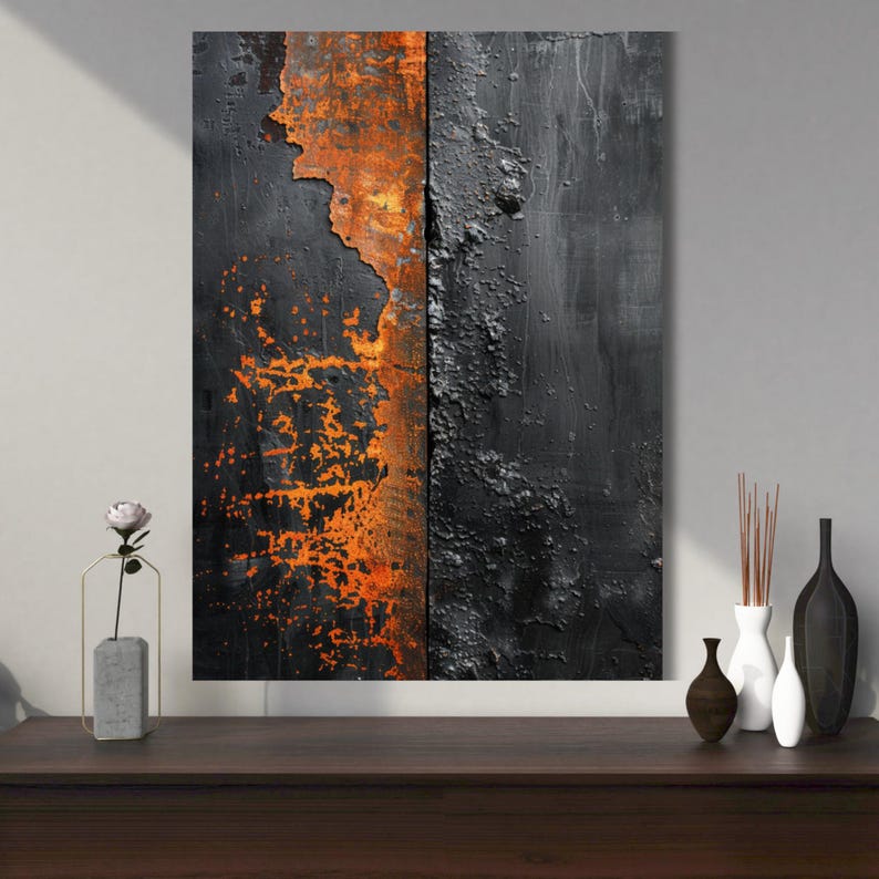 May include: Abstract wall art featuring a split design with a textured, weathered appearance. The left side displays vibrant orange rust against a black background, while the right side has a dark, textured surface. The artwork is displayed on a dark wooden surface.
