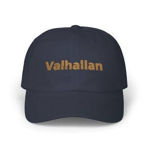 Könnte beinhalten: Eine marineblaue Baseballkappe mit dem Wort "Valhallan" in Braun auf der Vorderseite gestickt.