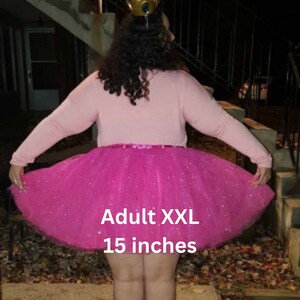 Pu&ograve; includere: Una gonna di tulle rosa con glitter argentati. La gonna &egrave; etichettata "Adult XXL 15 pollici".