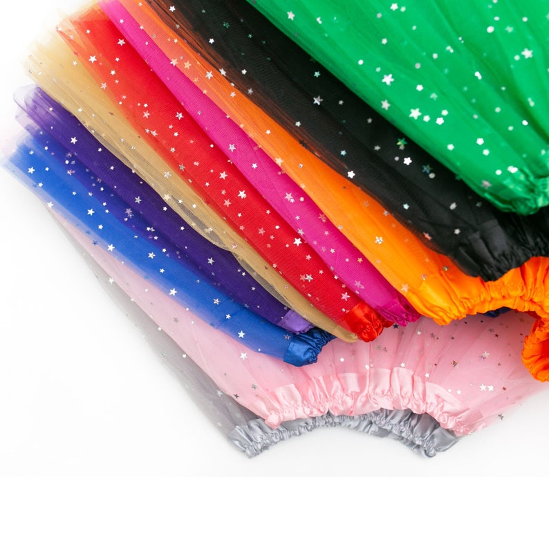 Pu&ograve; includere: Una pila di tessuto di tulle in vari colori, tra cui rosa, grigio, blu, viola, beige, rosso, arancione, nero e verde. Ogni pezzo di tessuto &egrave; decorato con stelle argentate scintillanti.