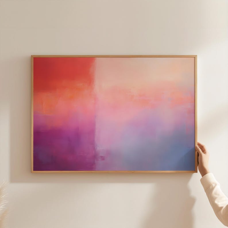 May include: Abstract painting with a gradient of pink, orange, purple, and blue colors. The painting is framed in a light wood frame.