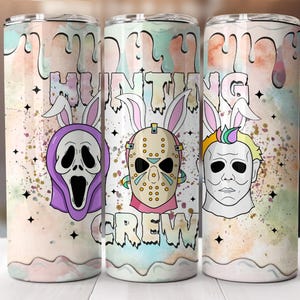 May include: Three stainless steel tumblers with a colorful design. Each tumbler features a horror movie character with bunny ears and the words "HUNTING CREW". The background has pastel colors and star accents.
