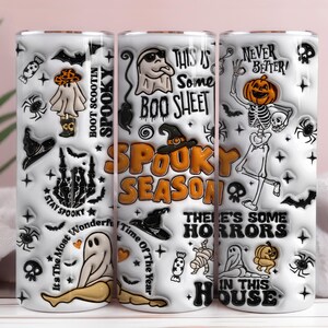 Könnte beinhalten: Ein weißer zylindrischer Becher mit einem Halloween-Muster aus Geistern, Kürbissen, Skeletten, Fledermäusen und Spinnen. Der Text umfasst 'THIS IS SOME BOO SHEET', 'SPOOKY SEASON', 'NEVER BETTER', 'STAY SPOOKY' und 'THERE'S SOME HORRORS IN THIS HOUSE'.
