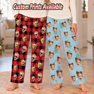 May include: Two pairs of pajama pants. One pair features a red and black buffalo plaid pattern with repeating dog faces wearing sunglasses. The other pair is light blue with repeating child faces, trees, and candy canes. Text reads Custom Prints Available.