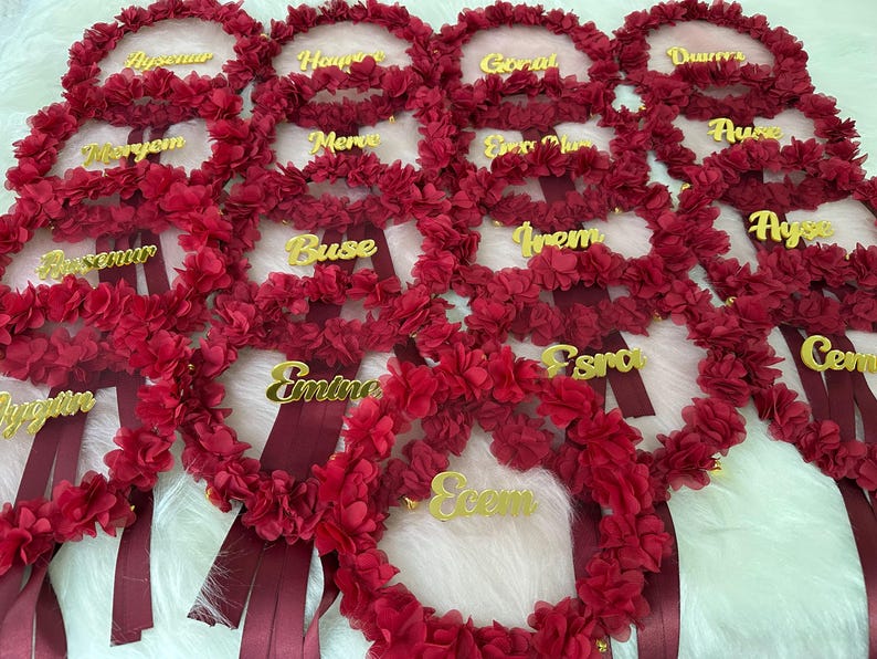 There are bridesmaid tambourines. bridesmaid text made by gold color arclic letters. frame made by laser cut flowers and some satin tails