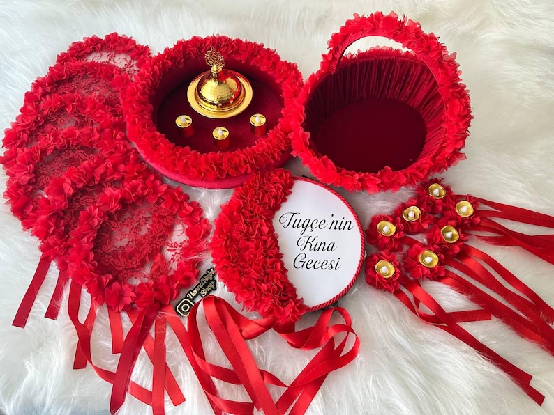 There are red bridesmaid tambourines, bride tsmbourine and henna tray henna basket frame made by laser cut flowers and some satin tails