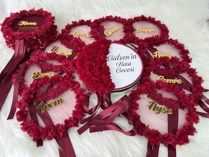 personalized text on henna bride tambourine. There are bridesmaid tambourines near them. bridesmaid text made by gold color arclic letters.