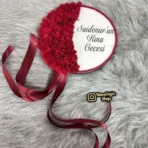 A red bride tambourines.  frame made by laser cut flowers and some satin tails