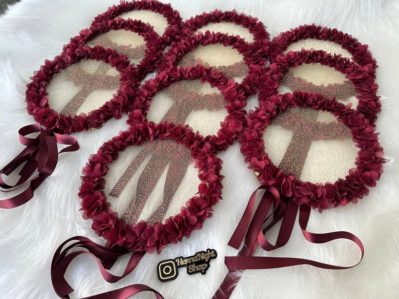 There are red bridesmaid tambourines.l. frame made by laser cut flowers and some satin tails