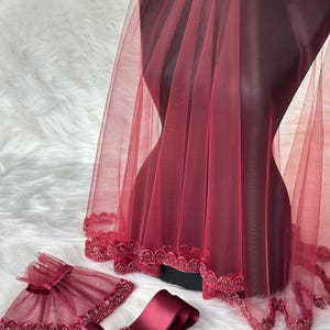Pu&ograve; includere: Un velo da sposa color borgogna con bordino perlato, una fascia in raso color borgogna abbinata e un braccialetto in tulle color borgogna con fiocco.