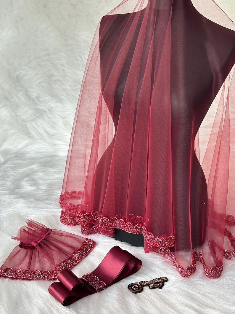 Pu&ograve; includere: Un velo da sposa color borgogna con bordino perlato, una fascia in raso color borgogna abbinata e un braccialetto in tulle color borgogna con fiocco.