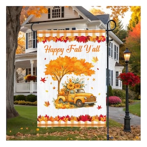 May include: A garden flag with a fall theme. The flag features a yellow truck carrying pumpkins and sunflowers under an orange tree. The text "Happy Fall Y'all" is displayed on a white background with fall leaves.