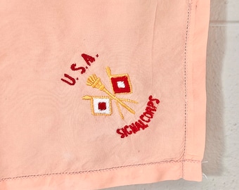 May include: A pink fabric handkerchief with embroidered text "U.S.A. SIGNAL CORPS" and a red, white, and gold insignia.
