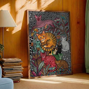 May include: A framed art print featuring a colorful illustration of various cats in a garden setting. The cats are depicted in a variety of colors and patterns, including orange, red, and pink. The background is a black and white dotted pattern.
