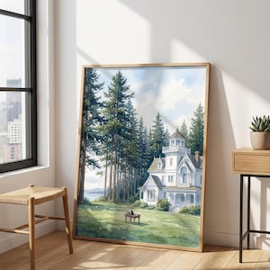 May include: A framed watercolor painting depicting a white multi-story house with a tower, situated in a lush green meadow surrounded by tall pine trees. A small black cat sits on a wooden bench in the foreground under a bright, cloudy sky.