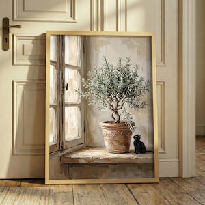 May include: A framed wall art print depicting a small potted olive tree with silvery-green leaves in a textured terracotta pot, placed on a ledge beside a window. A small black cat sits on the ledge next to the pot, looking up at the tree.