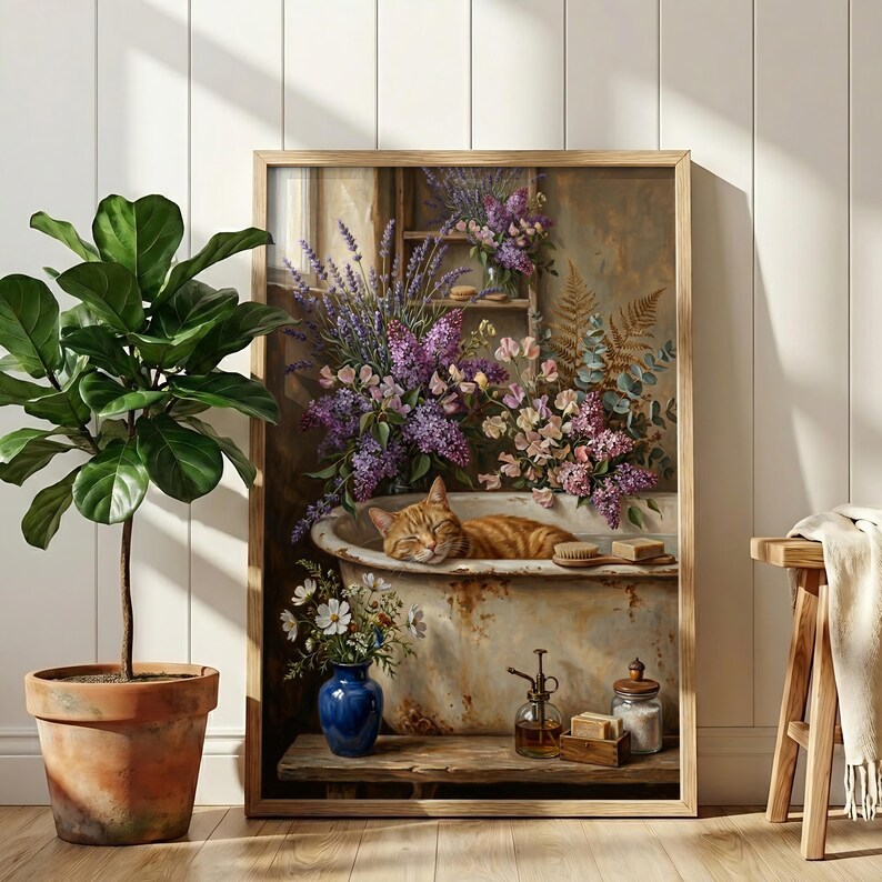 K&ouml;nnte beinhalten: Ein gerahmtes Kunstwerk zeigt eine schlafende rot getigerte Katze in einer Vintage-Badewanne, umgeben von Blumen. Das Gem&auml;lde hat einen Holzrahmen, eine blaue Vase und einen Holzschemel. Das Kunstwerk wird neben einer Topfpflanze ausgestellt.