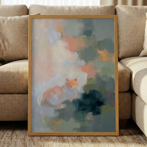 May include: A framed abstract painting featuring a cat in shades of peach, pink, and orange, set against a backdrop of muted greens, blues, and grays. The artwork is enclosed in a light brown wooden frame, creating a soft, artistic aesthetic.