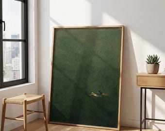 May include: A large rectangular framed wall art piece featuring a deep forest green background with two small figures swimming in the lower right corner. The frame is made of light-toned wood, and the artwork depicts a vast, dark water surface.