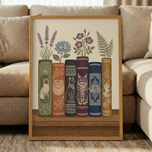 May include: A framed art print featuring six decorative book spines, each with a different cat illustration and topped with various plants. The color palette includes greens, oranges, blues, and browns, creating a vintage aesthetic.
