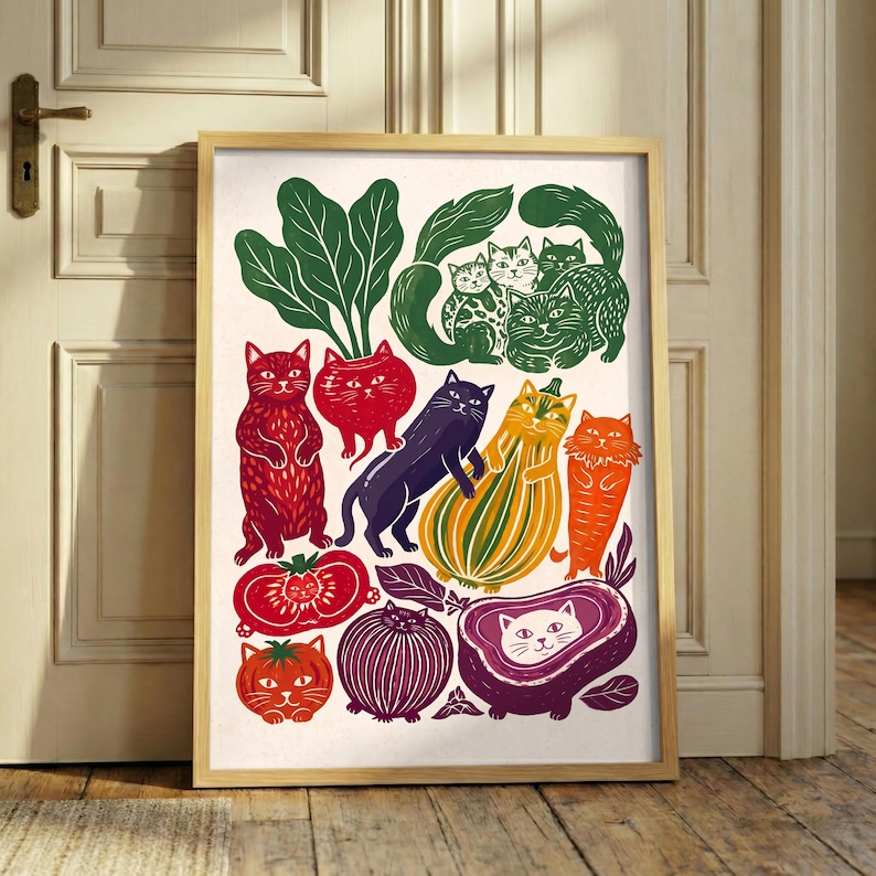 May include: A framed art print featuring a collection of stylized cats integrated with various vegetables and fruits. The illustration includes green leafy greens, red tomatoes, a purple onion, a striped squash, and a purple eggplant, all with cat faces.